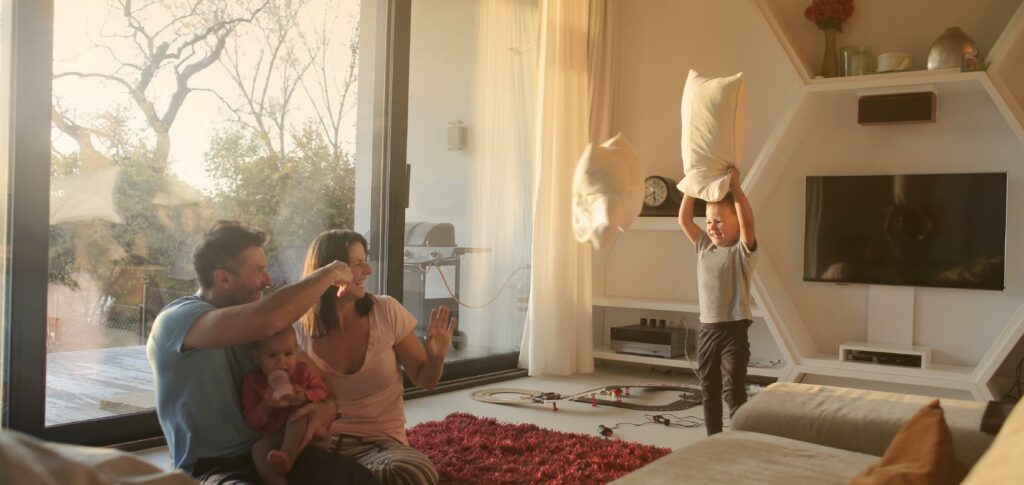 Junge Familie im Wohnzimmer in der Abendsonne