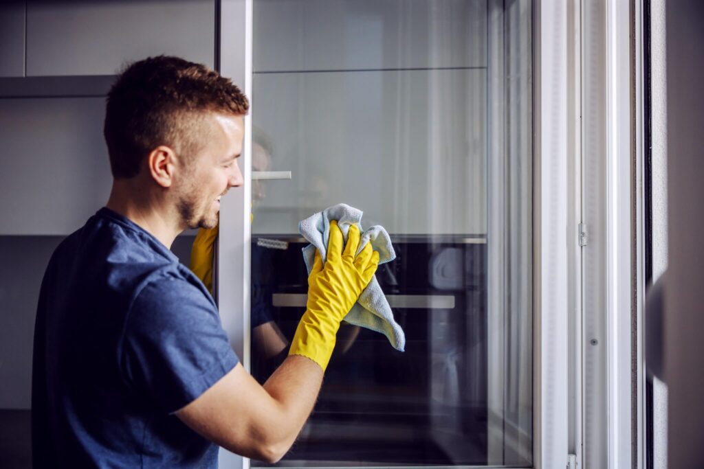 Mann putzt Fenster