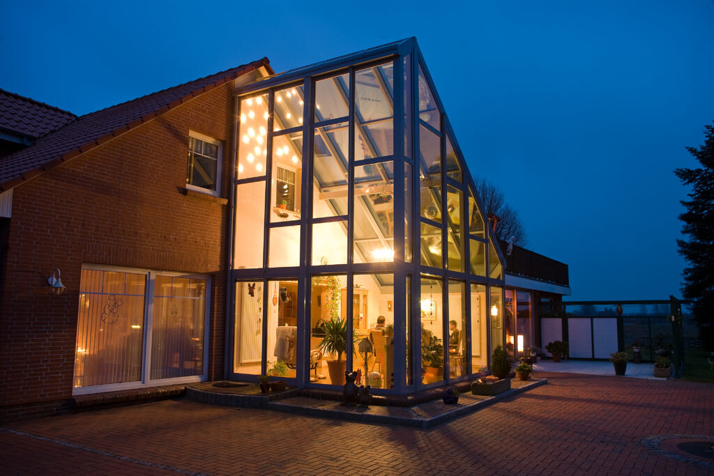Wintergarten als Hausanbau bei Nacht
