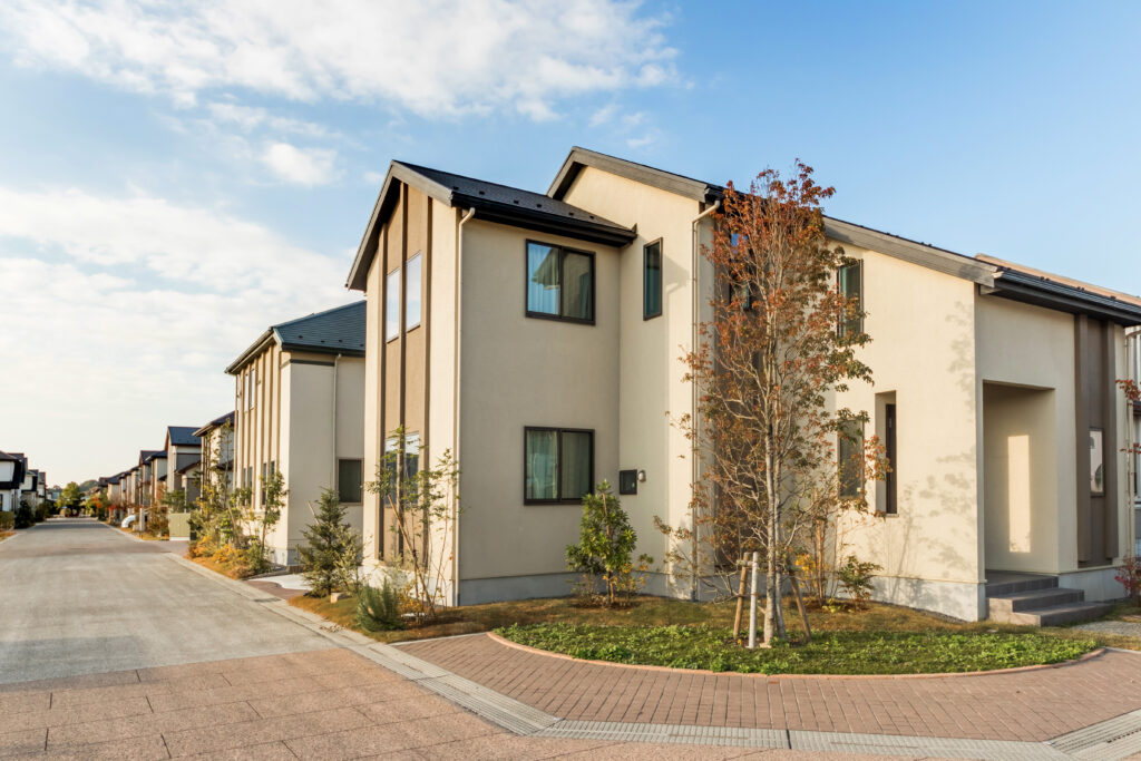 Modernes, nachhaltiges, beiges Haus in neuer Wohnsiedlung